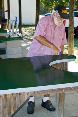 man painting table at range